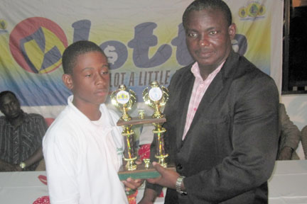 Grenada’s Emmanuel Stewart, left, receives a trophy from Parliamentary Secretary in the Ministry of Sports, Sen. Elvis Charles.